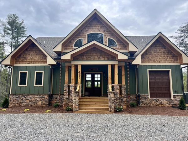 a green house with a gravel driveway